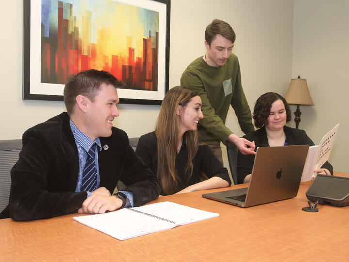 four faculty around desk