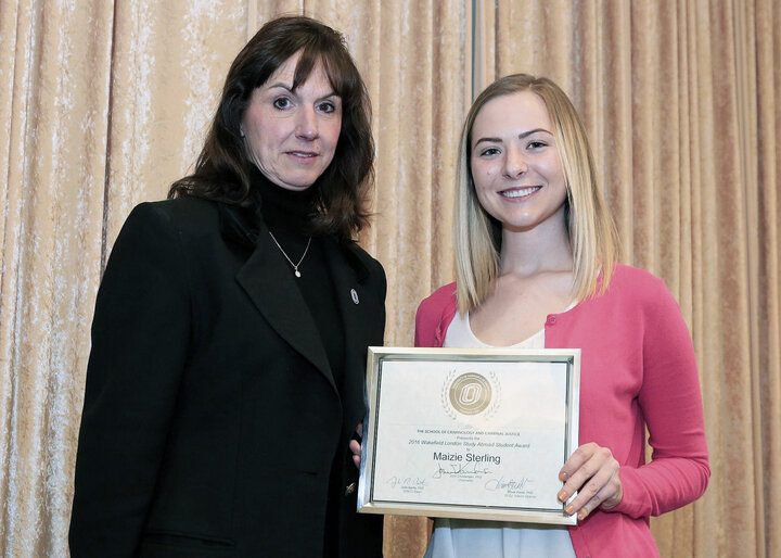 female student receiving certificate from female faculty